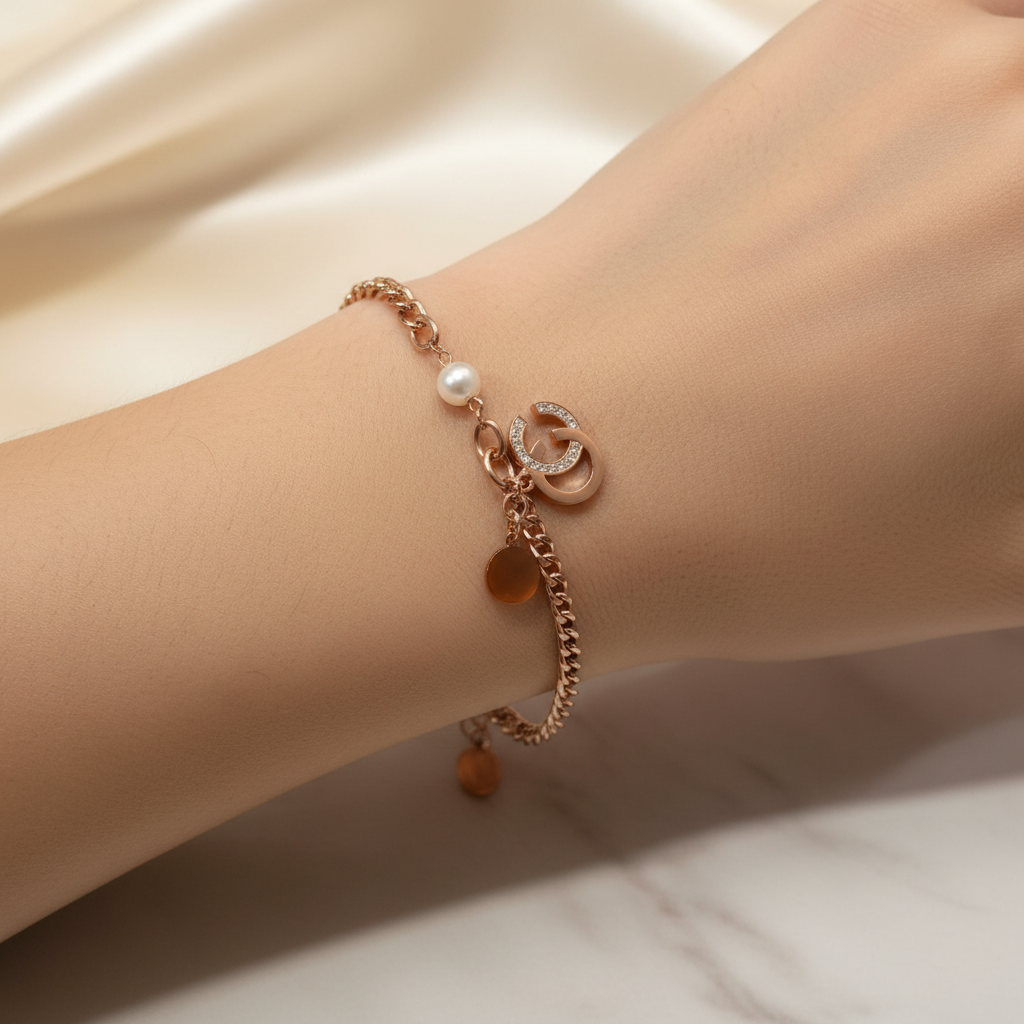 Beautiful slender wrist with rose gold pearl, crescent moon, and disc charm bracelet