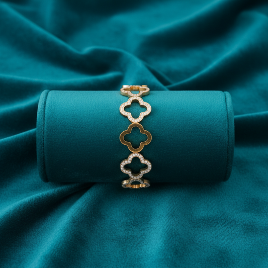 Alternating quatrefoil clover bracelet on teal jewelry cushion with teal background