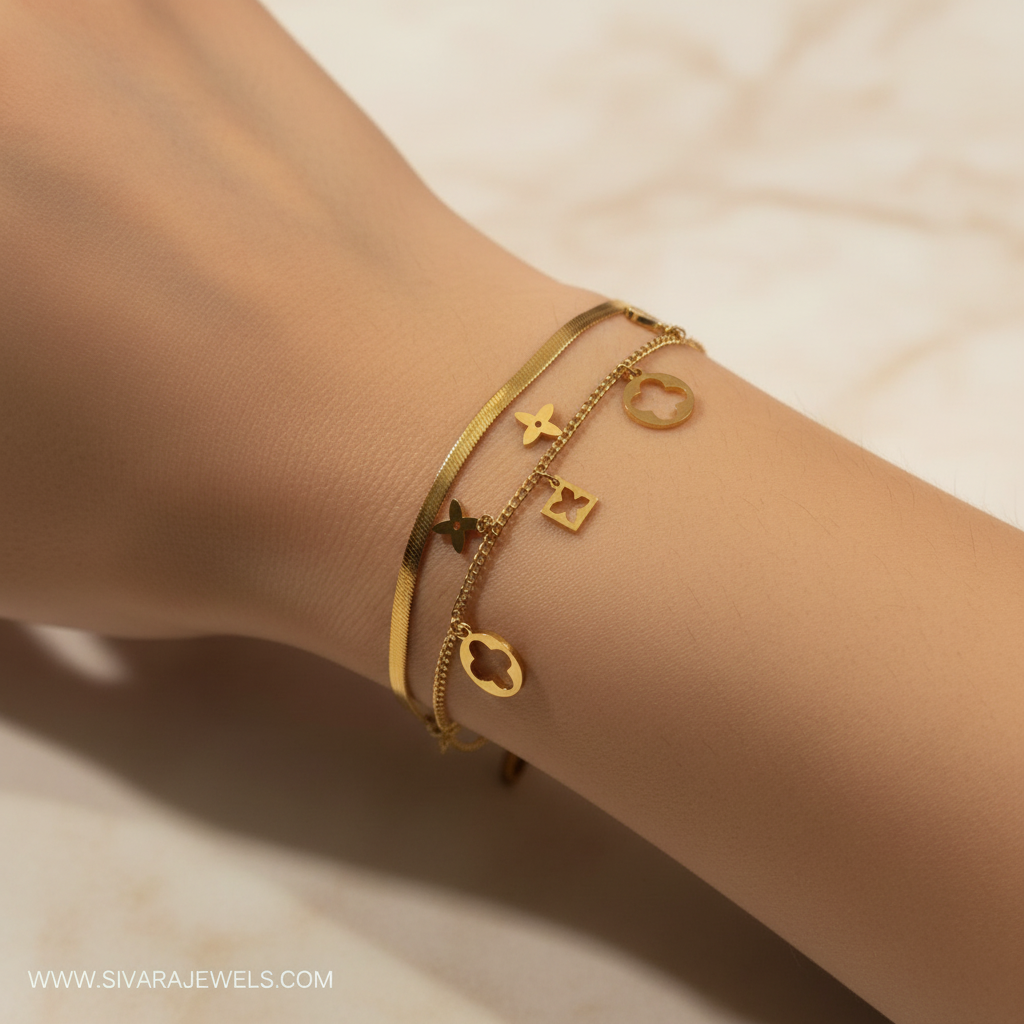 Beautiful slender wrist with gold double-layered herringbone and charm bracelet