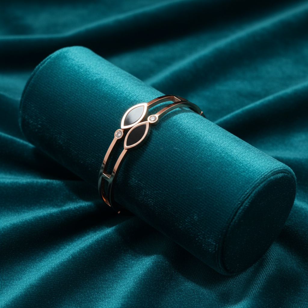 Rose gold black enamel marquise and diamond bracelet on teal jewelry cushion with teal background