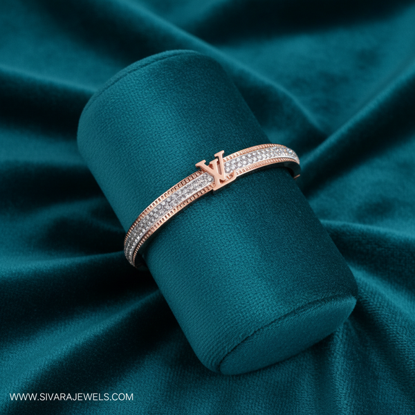 Rose gold designer logo and diamond bracelet on teal jewelry cushion with teal background