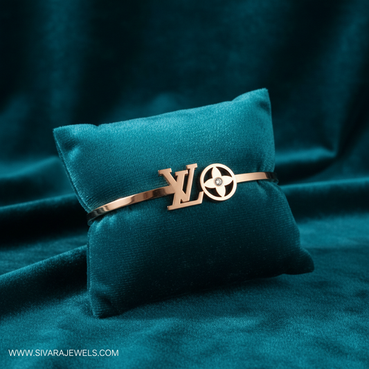 Rose gold designer logo and diamond bracelet on teal jewelry cushion with teal background